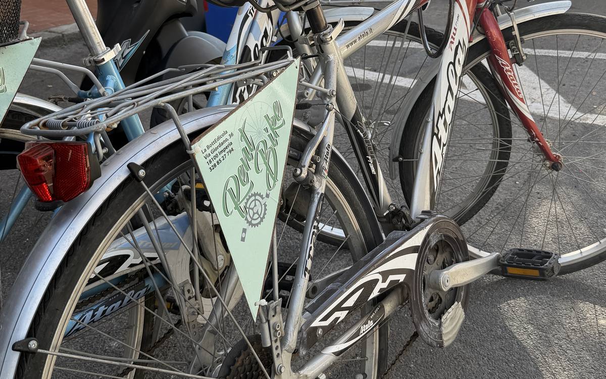 Biciclette a noleggio con il gagliardetto Rent Bike davanti alla bottega